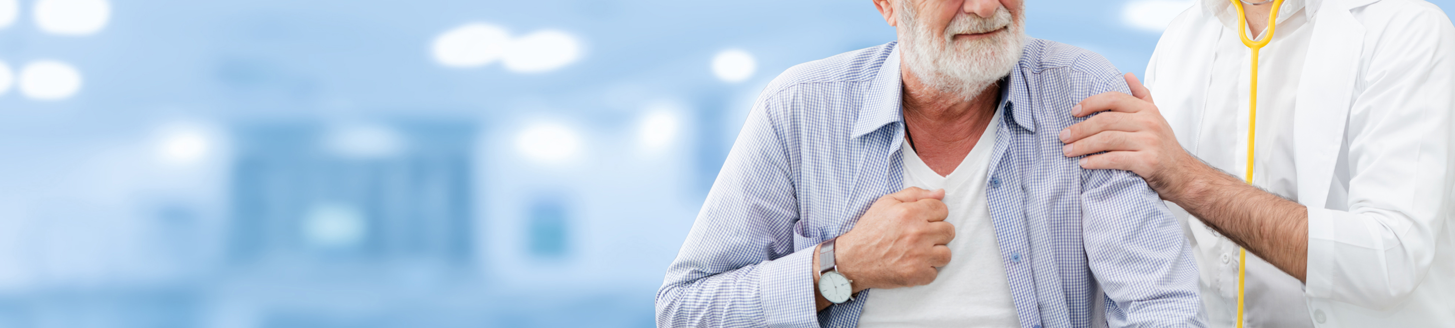 Ein älterer Mann mit weißem Bart hält sich schmerzverzerrt die Brust, während ein Arzt in weißem Kittel und mit gelbem Stethoskop ihn beruhigend an der Schulter berührt. Die Szene spielt in einem hell beleuchteten, verschwommenen Klinik- oder Krankenhausumfeld und deutet auf eine mögliche akute Herzbeschwerde hin.