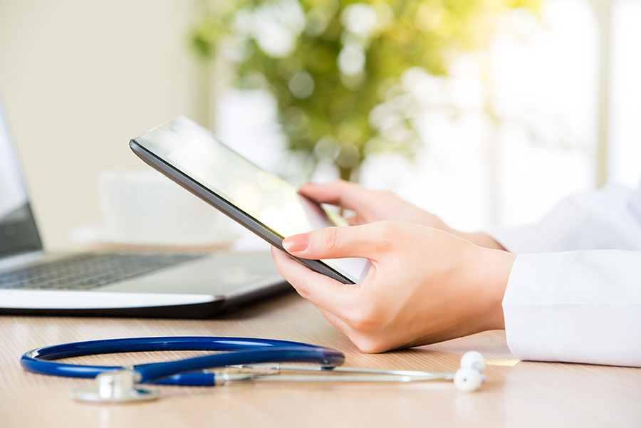 Zwei Hände halten ein Tablet.