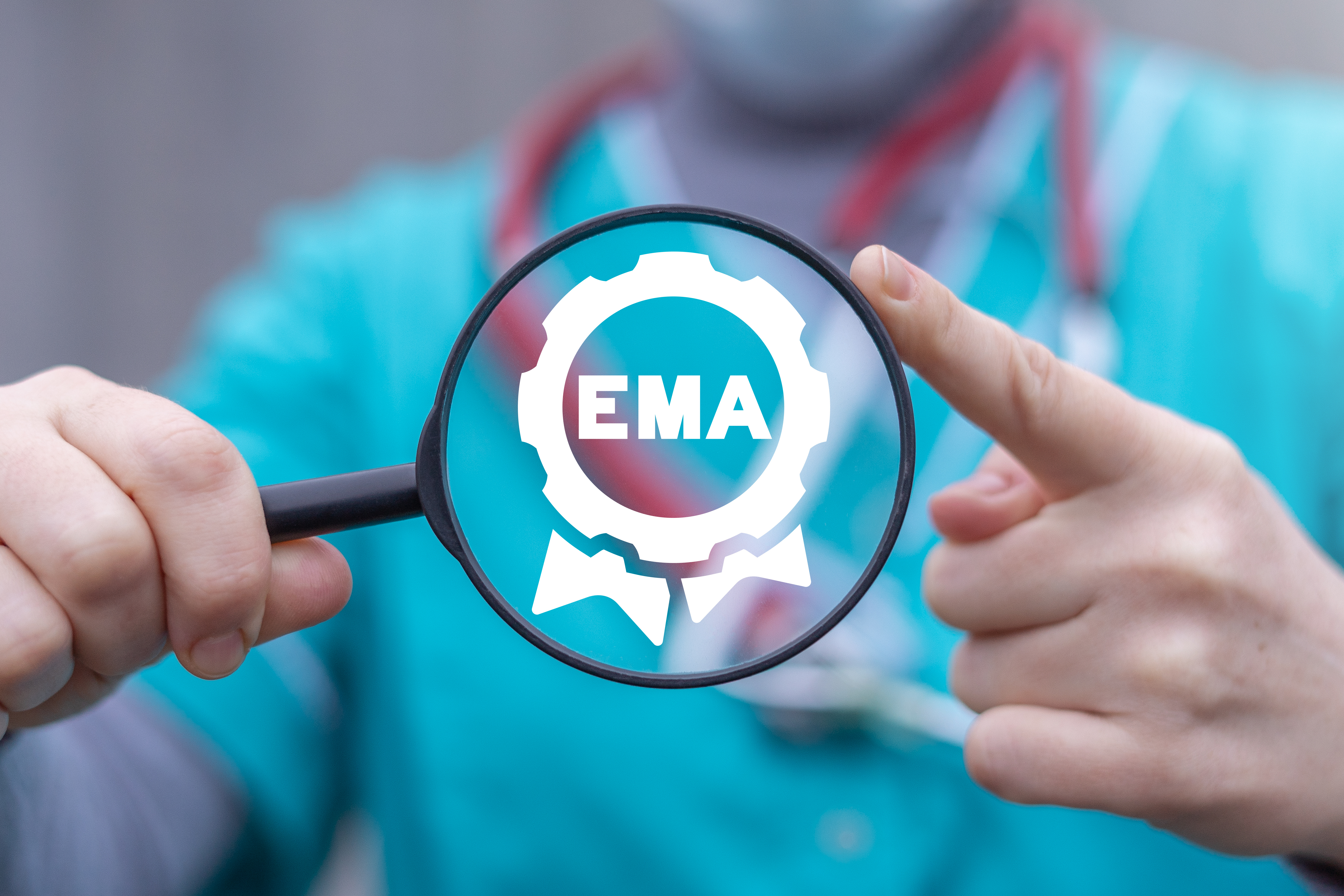  Ein Arzt hält eine Lupe in der EMA steht.