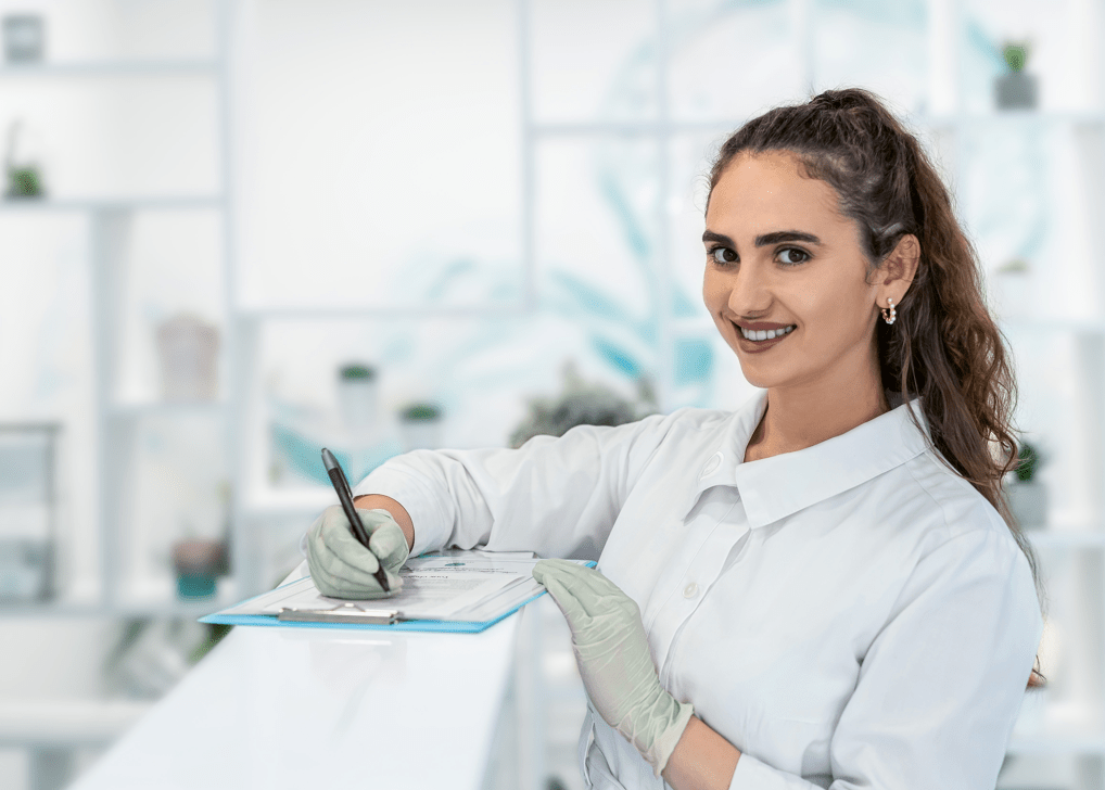 Eine lächelnde Frau im weißen Kittel.