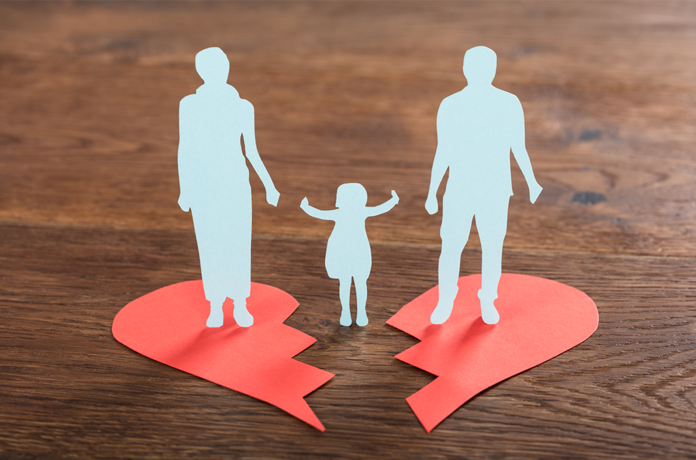 Der Umriss eines kleinen Kindes steht zwischen dem Umriss seiner Eltern.