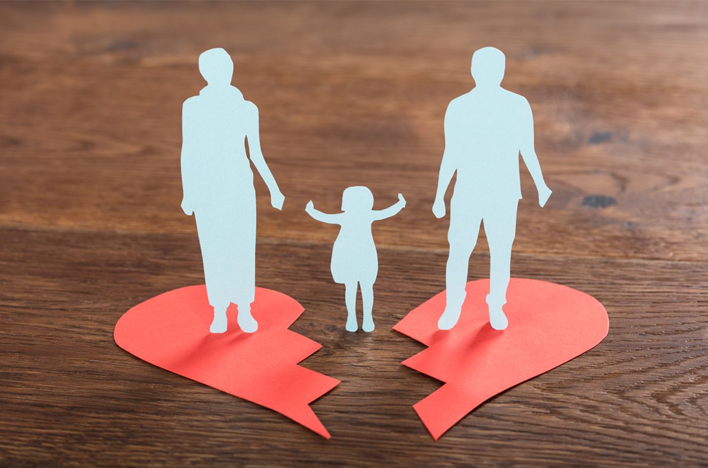 Der Umriss eines kleinen Kindes steht zwischen dem Umriss seiner Eltern.