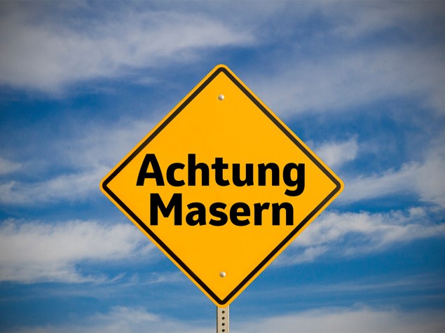 Gelbes Warnschild, mit der Aufschrift „Achtung Masern“.