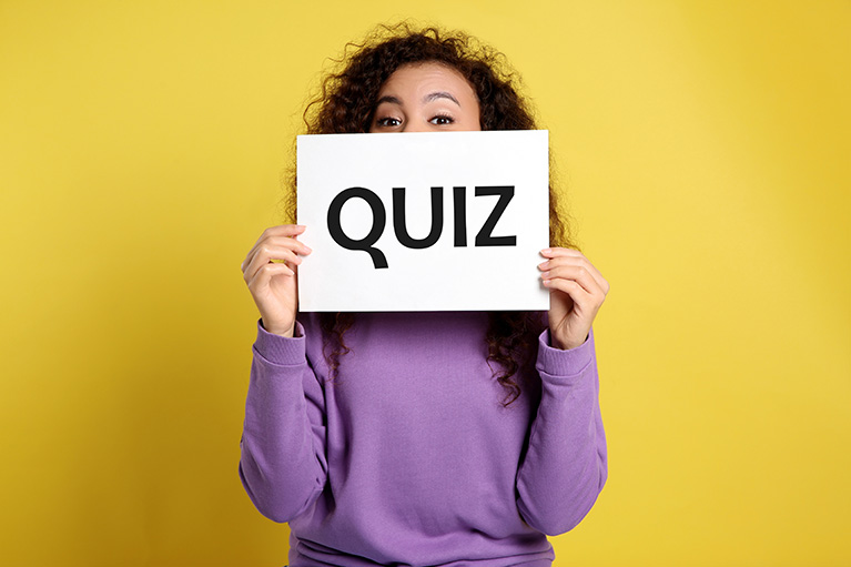 Frau hält Schild mit der Aufschrift Quiz vor das Gesicht