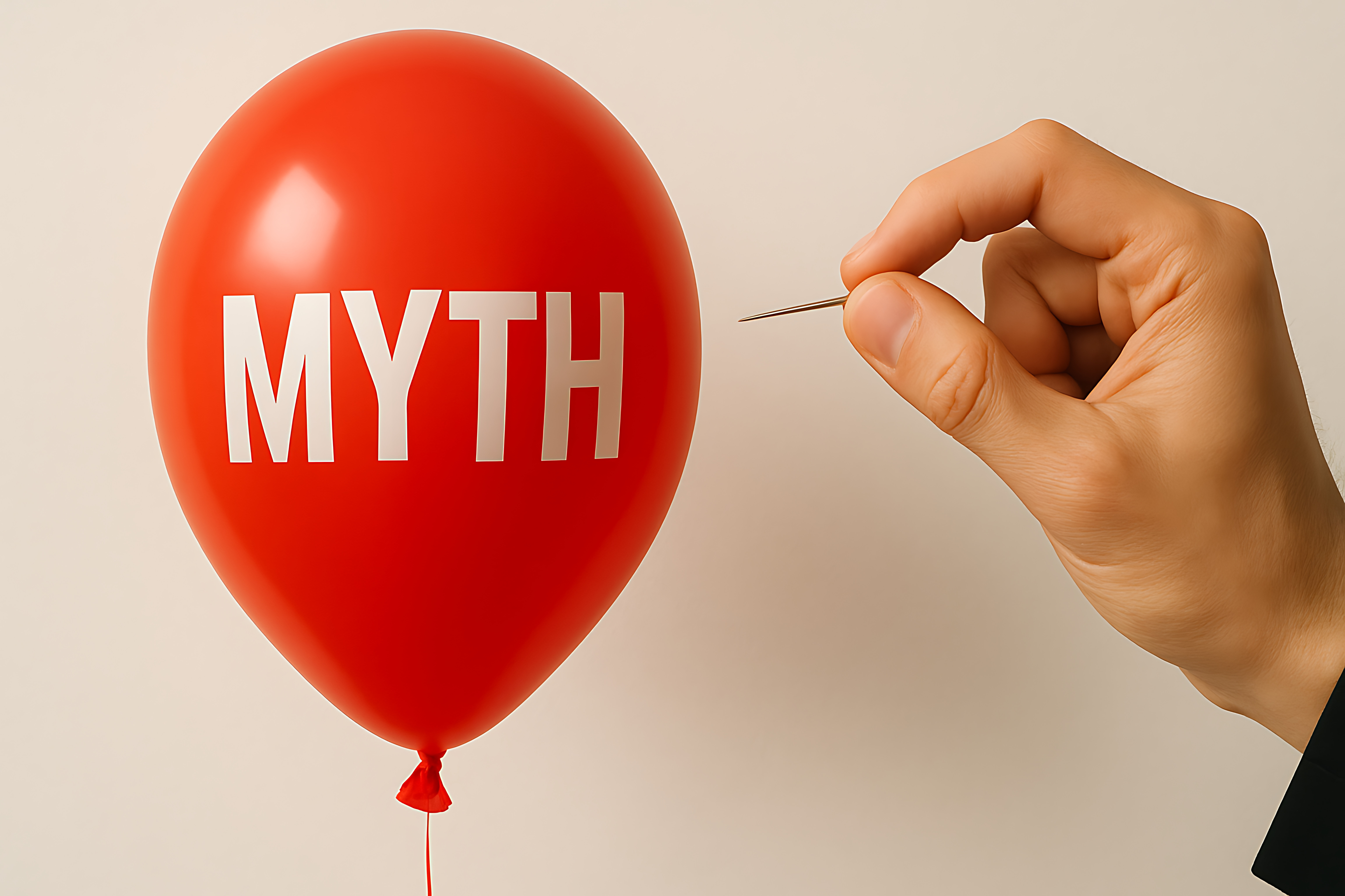 Luftballon mit dem Wort Myth, in den gleich eine Nadel gestochen wird