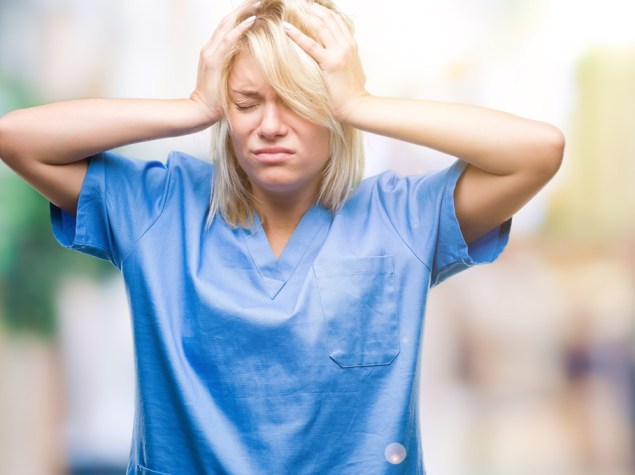 Gestresste MFA hält sich mit geschlossenen Augen den Kopf.